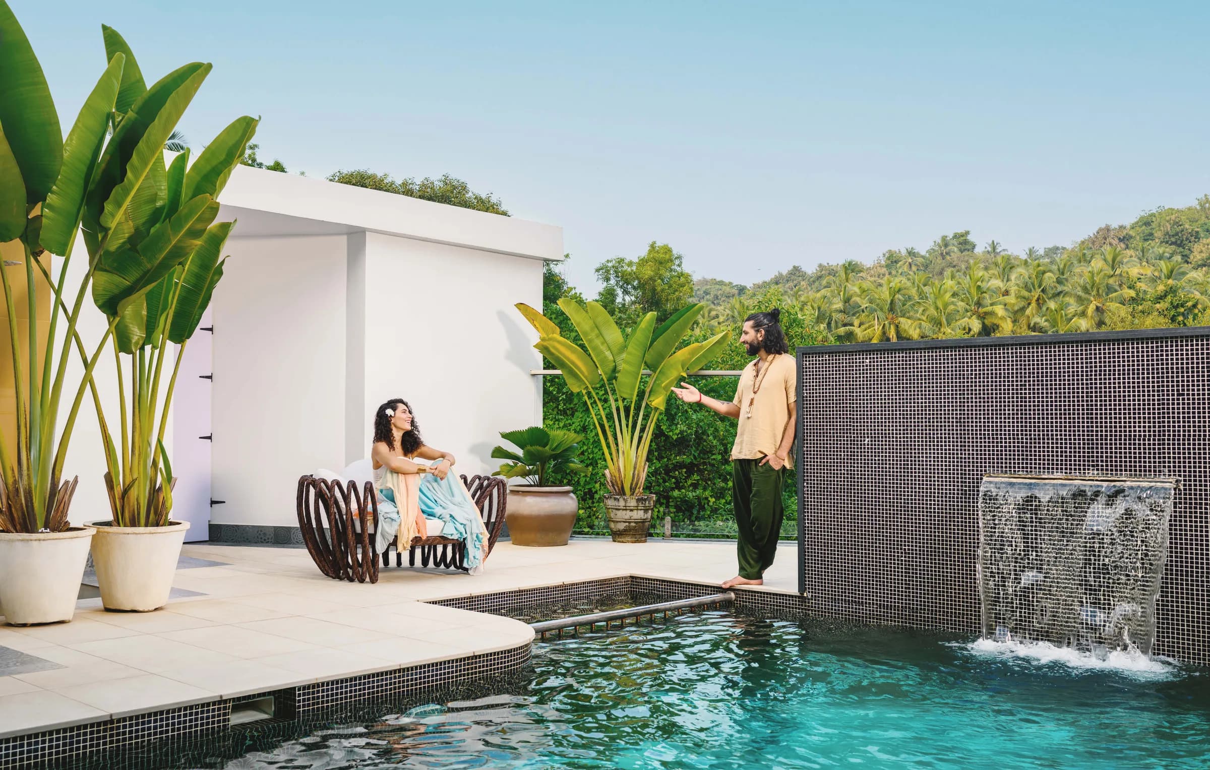 Curved pool edges, tropical planting and a tiled waterfall