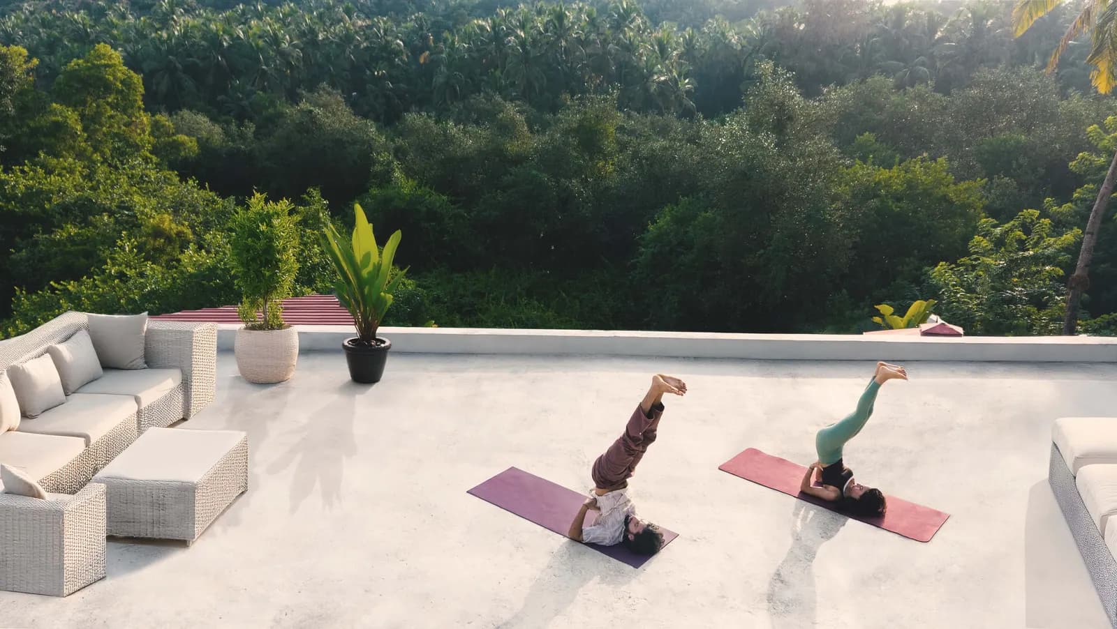 Two people practising yoga on the rooftop terrace at Villa Raag